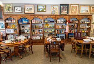 Display shelves with kitchenware, books, and dining tables