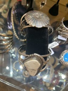 Silver cuff bracelets with stone settings on display