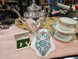 Silver teapot, floral porcelain teacups, a beaded mesh evening bag, and boxed Krementz earrings